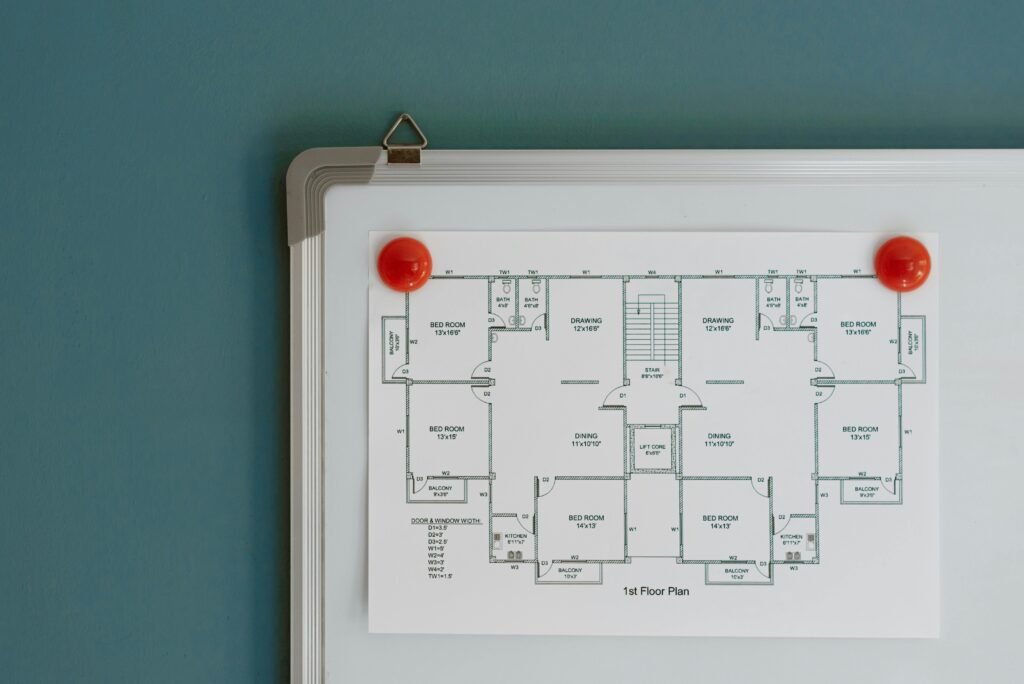 Detailed architectural floor plan pinned on a whiteboard with red magnets.