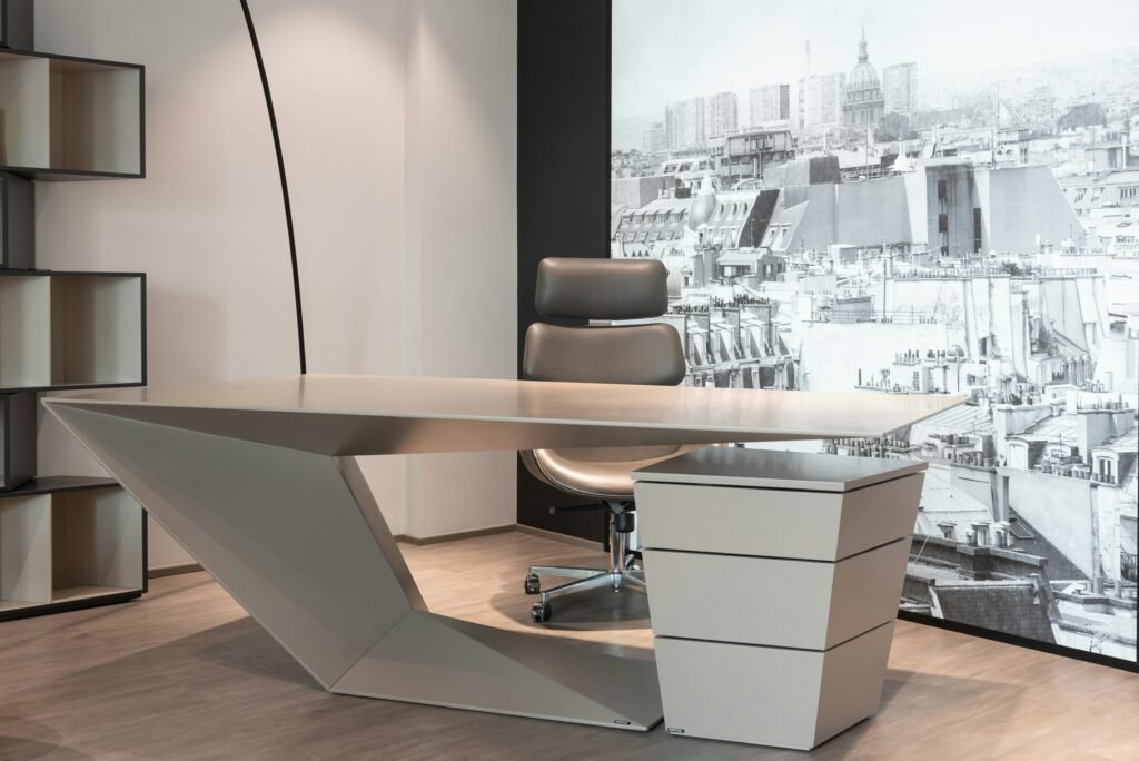 Interior of contemporary office with comfortable chair and futuristic table near cupboard against wall with printed wallpaper